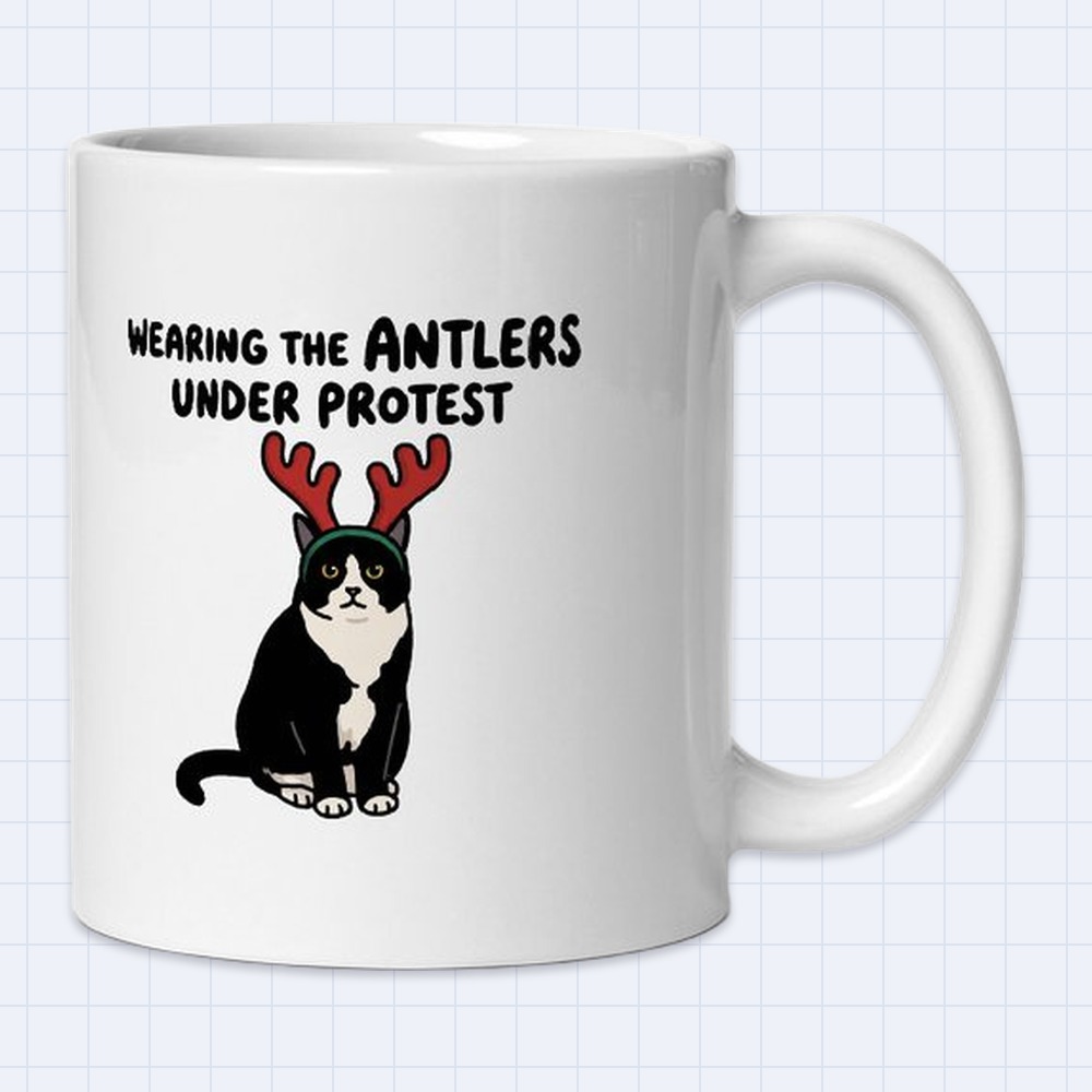 Funny Tuxedo Cat with Reindeer Antlers Mug – "Wearing the antlers under protest" | 11 oz White Ceramic Coffee Mug